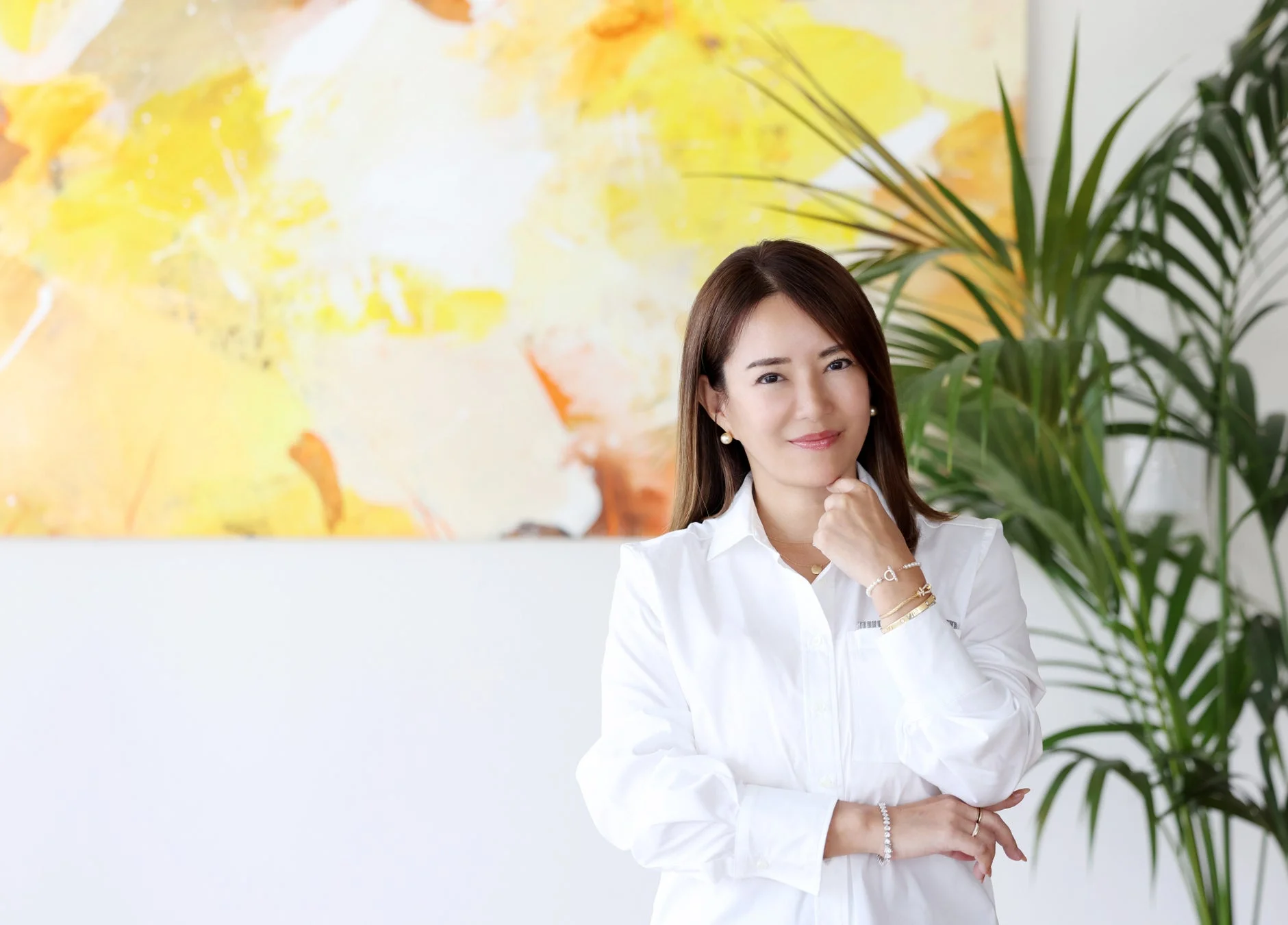 白いシャツを着て笑顔でポーズをとる河村真木子氏