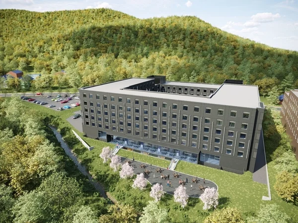 緑豊かな山間に建つモダンなデザインの宿泊施設を上空から捉えた画像