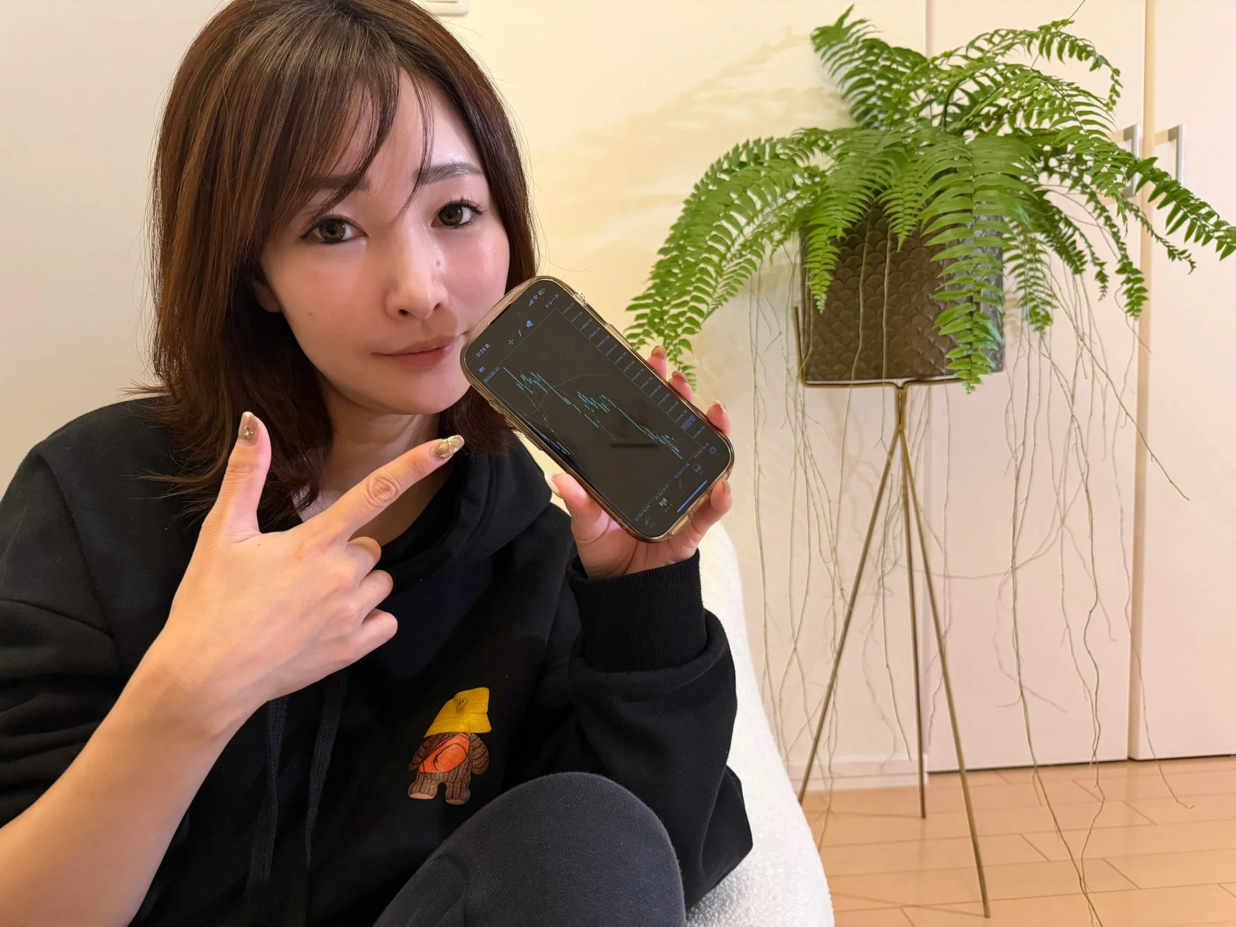 スマートフォンでチャートを見せる女性