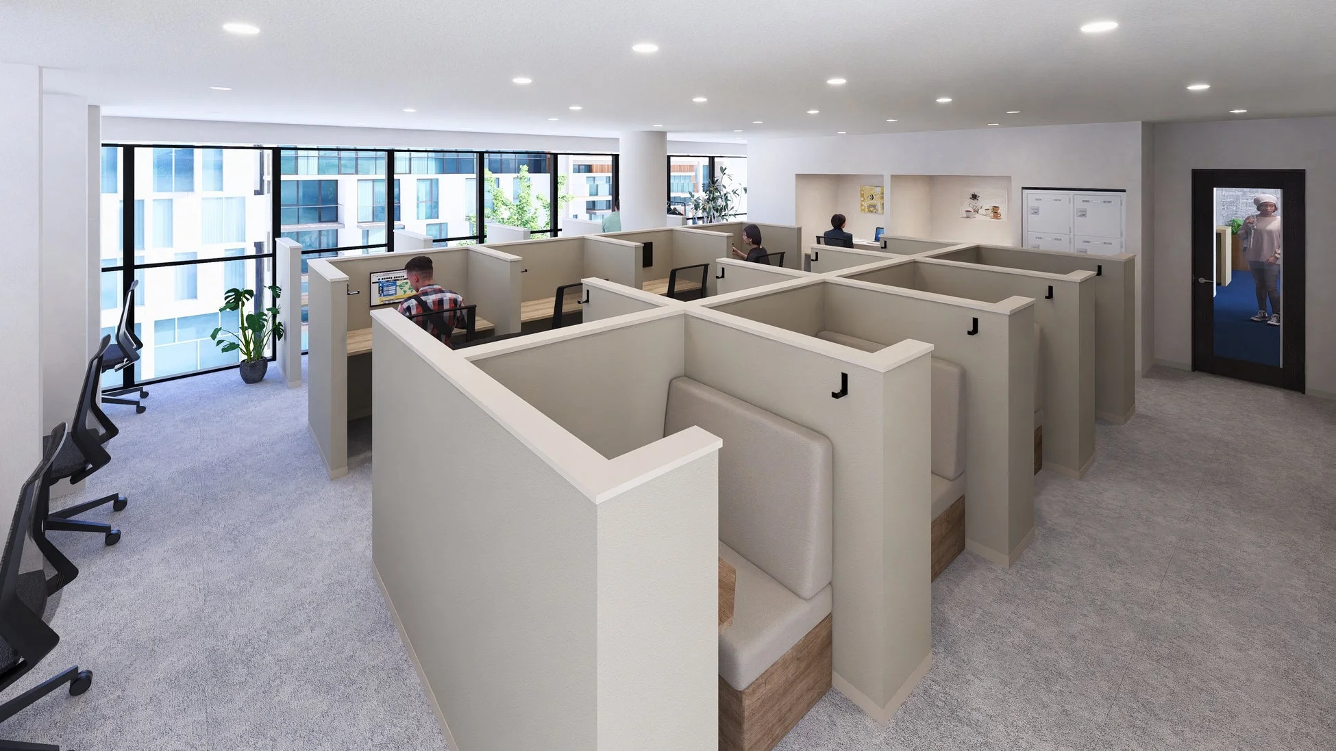 広々としたモダンなオフィス空間で、複数の従業員が個別のブースやデスクでパソコン作業をしている様子