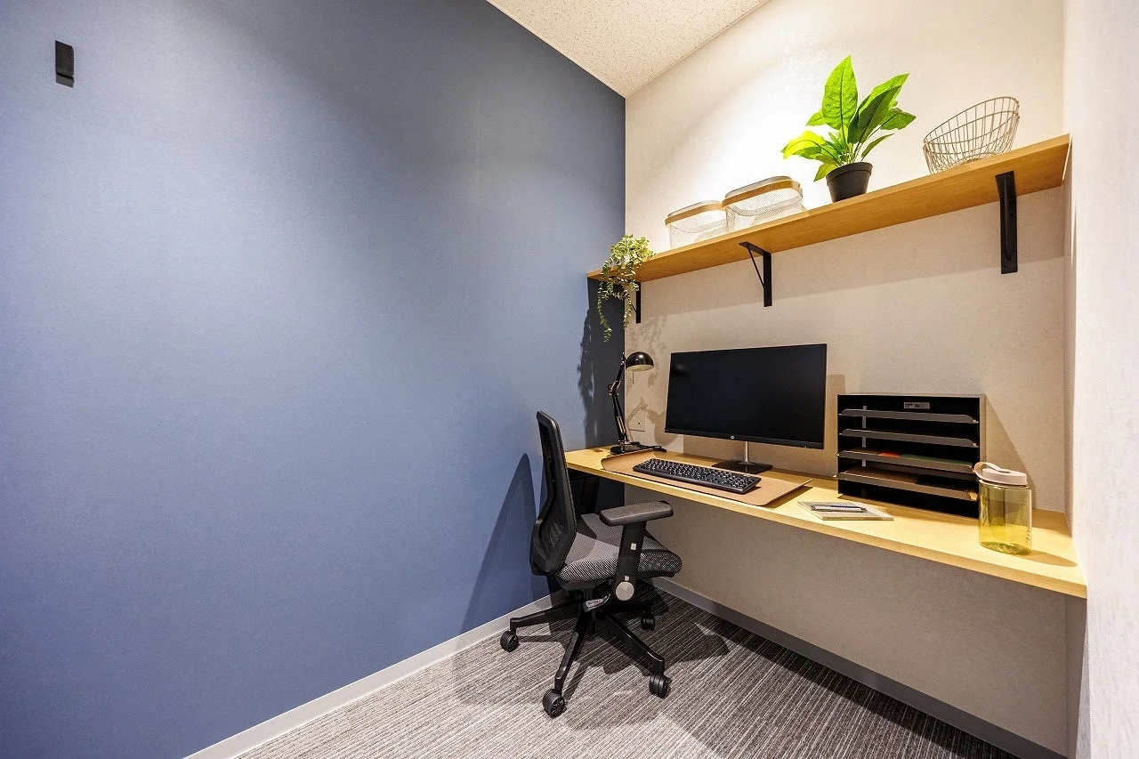 青い壁と白い壁で構成されたモダンなワークスペース