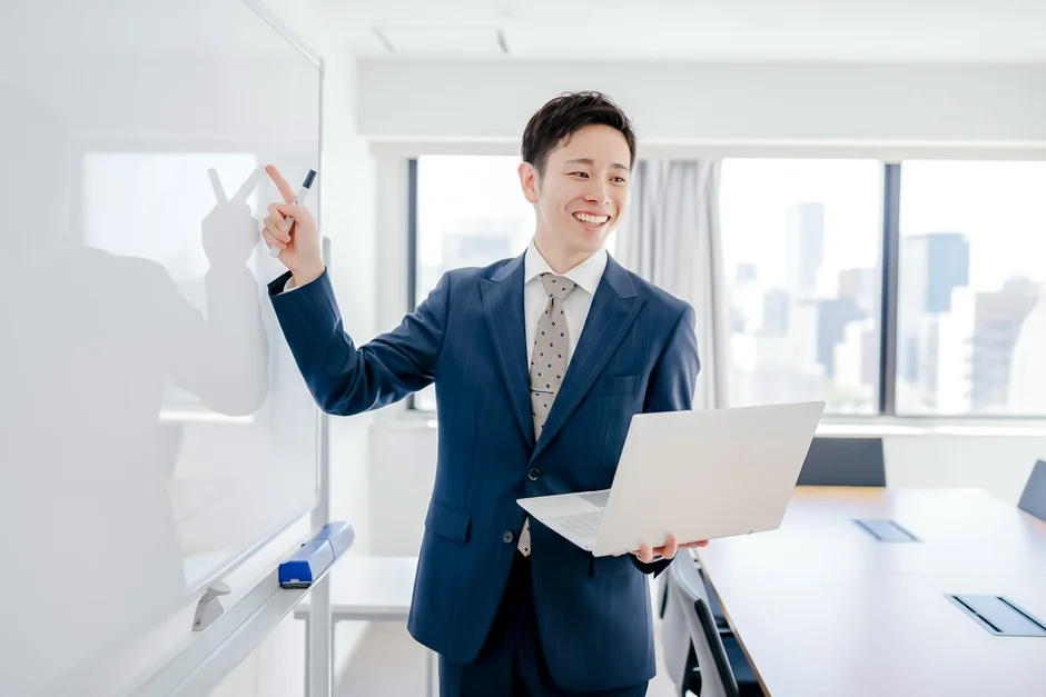 ビジネスマンがホワイトボードを指す様子