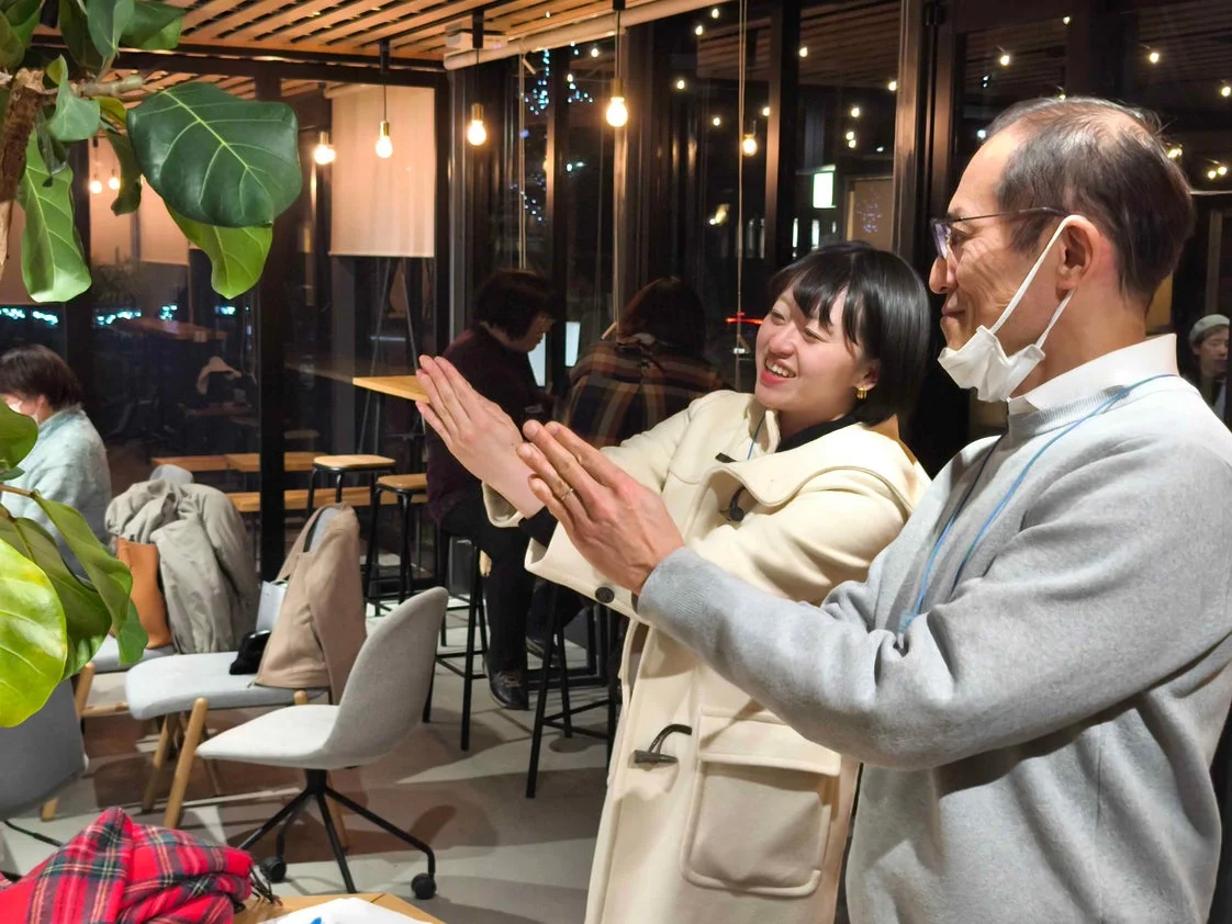 カフェのような空間で笑顔で会話する男女