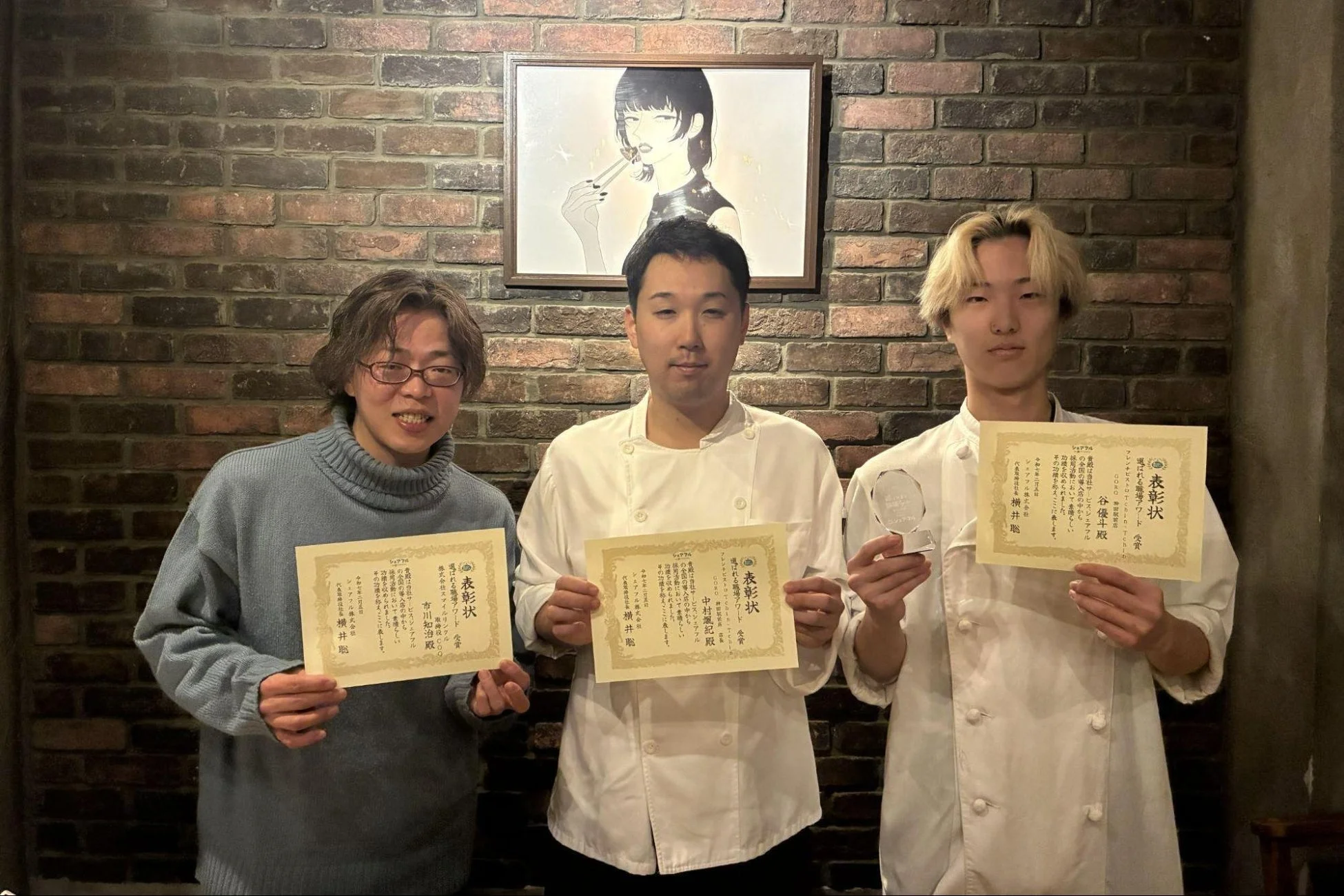 表彰状とトロフィーを受け取る3人の男性の記念写真