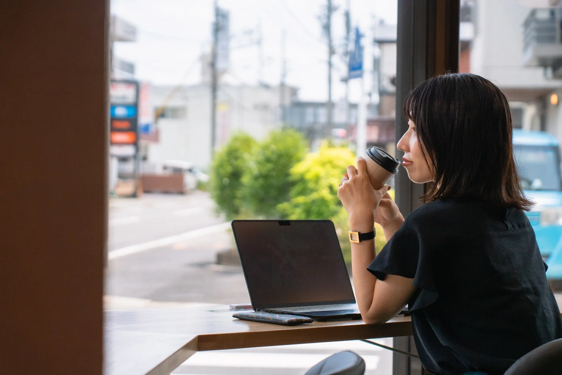 カフェの窓際でPC作業をする女性