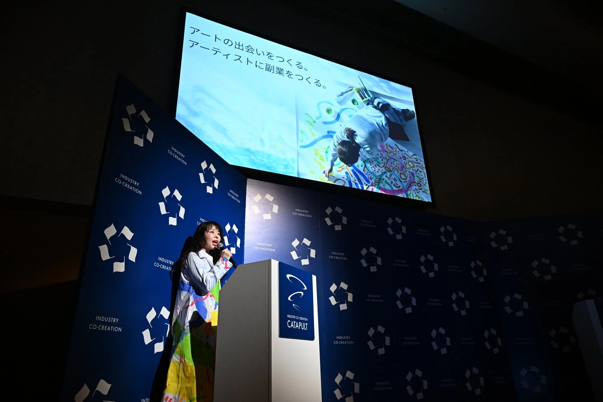 ステージでプレゼンテーションを行うリフレクトアート代表