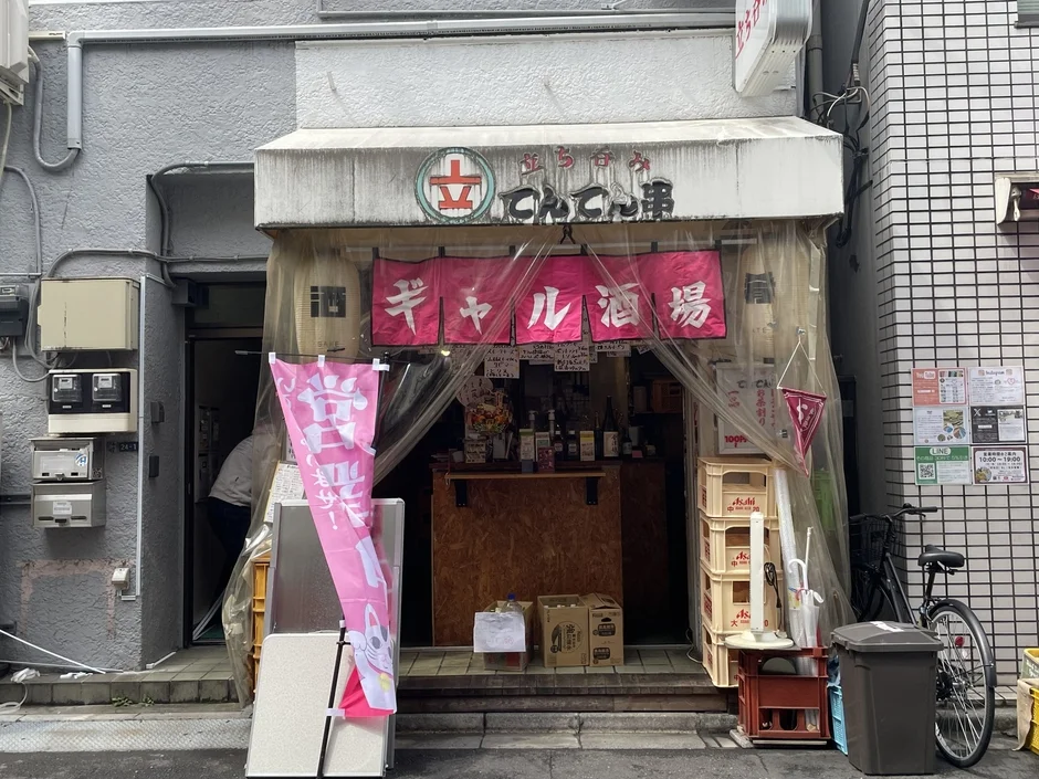 日本の街角にある「立呑み串 ギャル酒場」という立ち飲み屋の店頭。