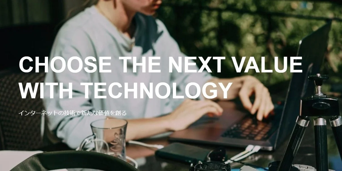 屋外でラップトップを使用する人物の画像