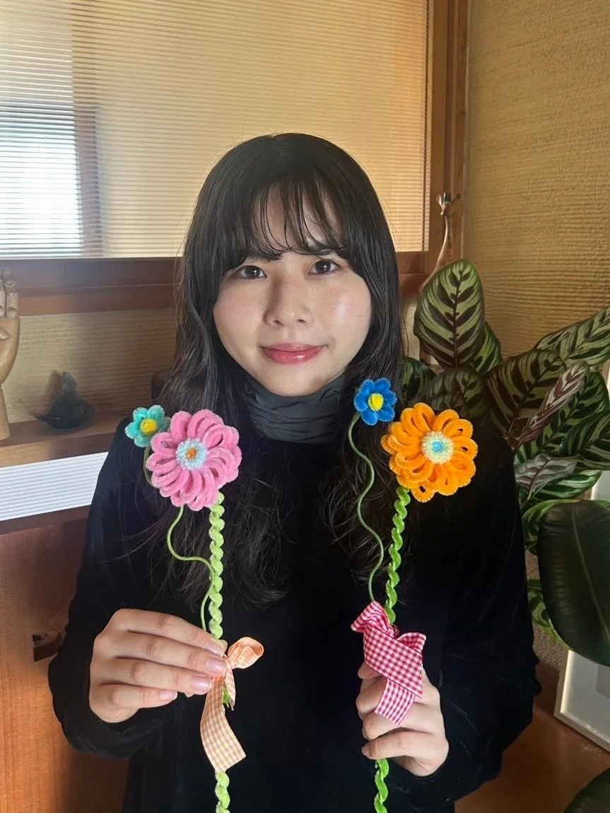 笑顔で花飾りを持つ女性