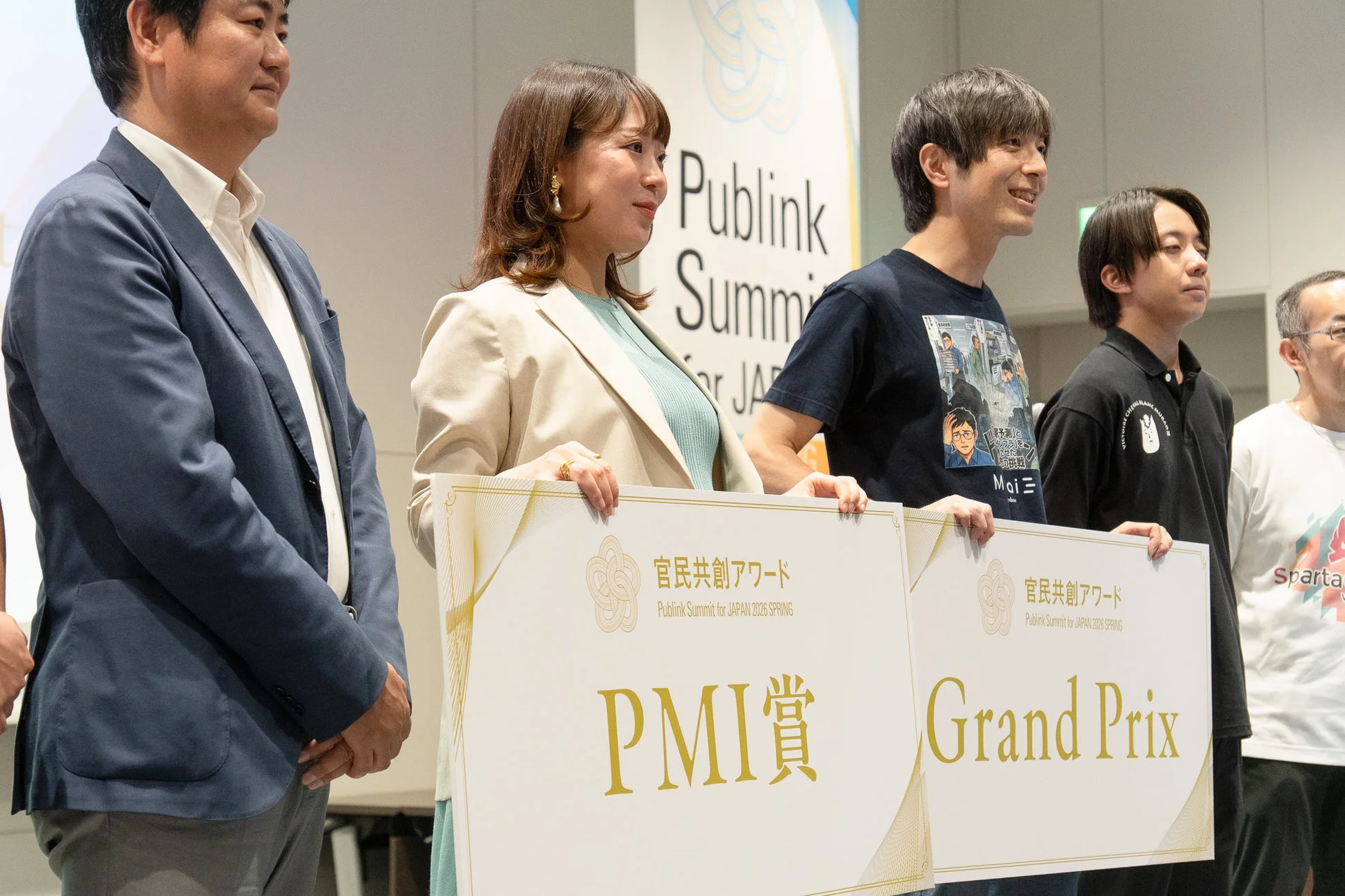 官民共創アワードの授賞式で「PMI賞」のボードを手にしている登壇者たち