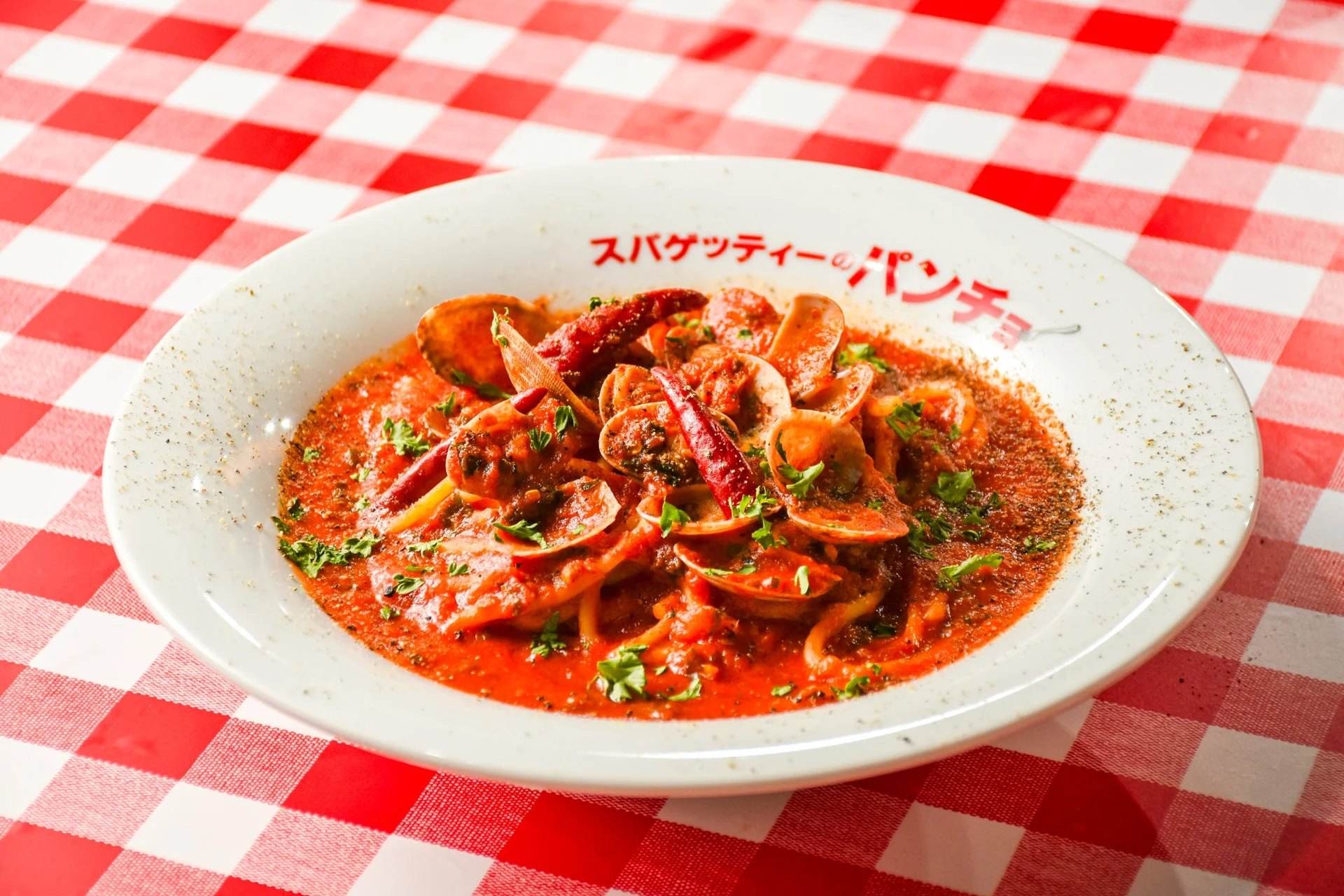アサリと唐辛子が入った真っ赤なトマトソースのスパゲッティ