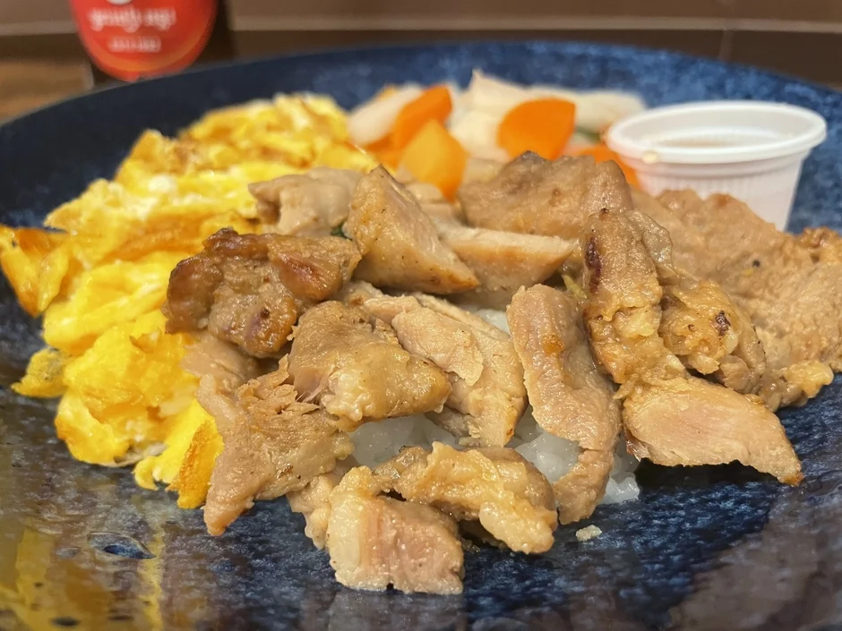 ご飯の上に炒めた肉とスクランブルエッグがのった一皿