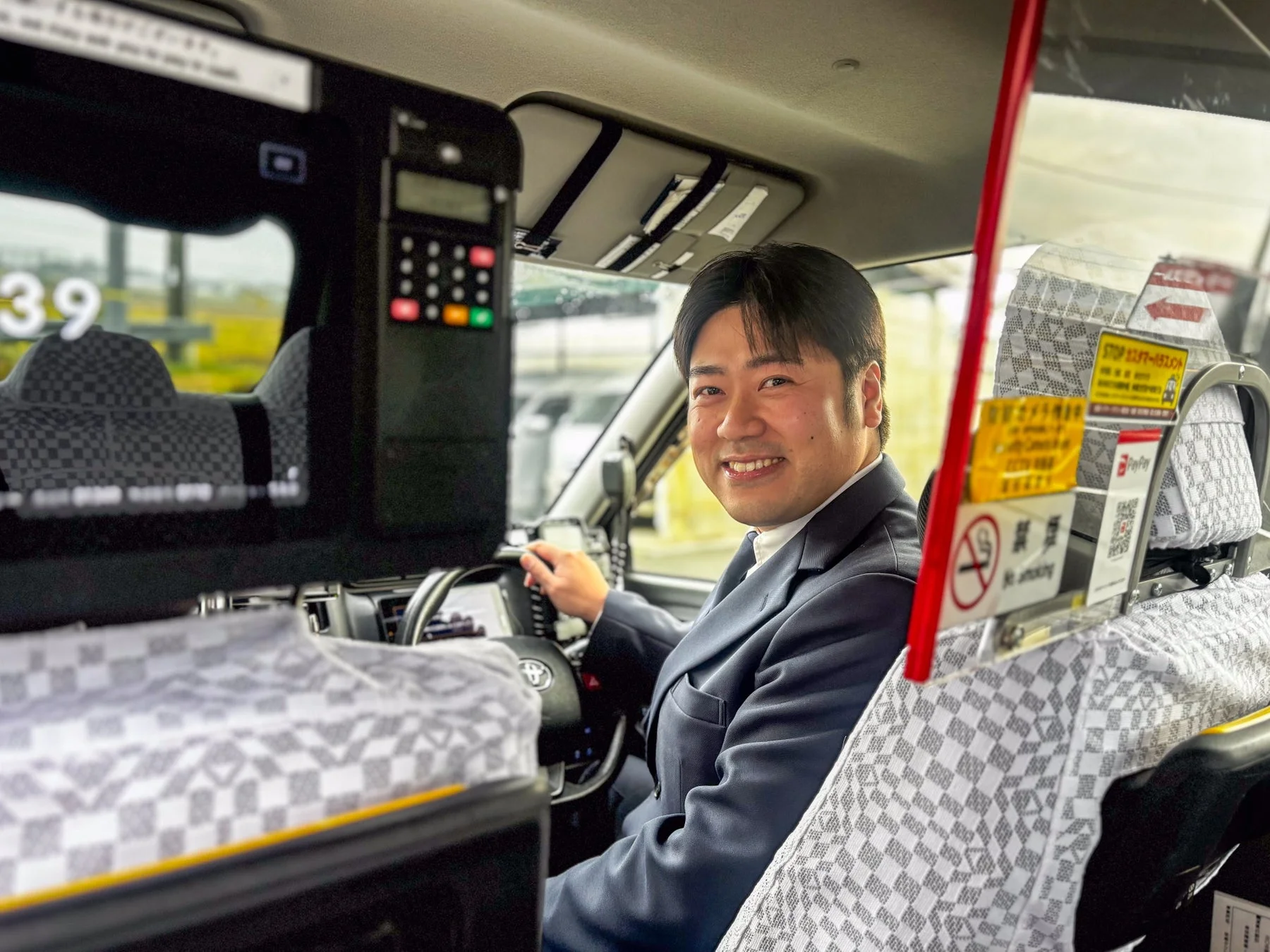 笑顔のタクシー運転手と車内