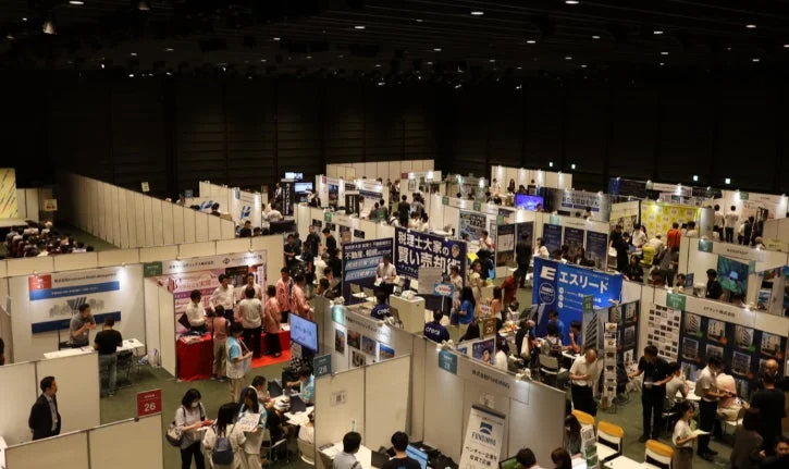 広々とした会場で多数の企業ブースが出展し、多くの人々が訪れている展示会の様子です。