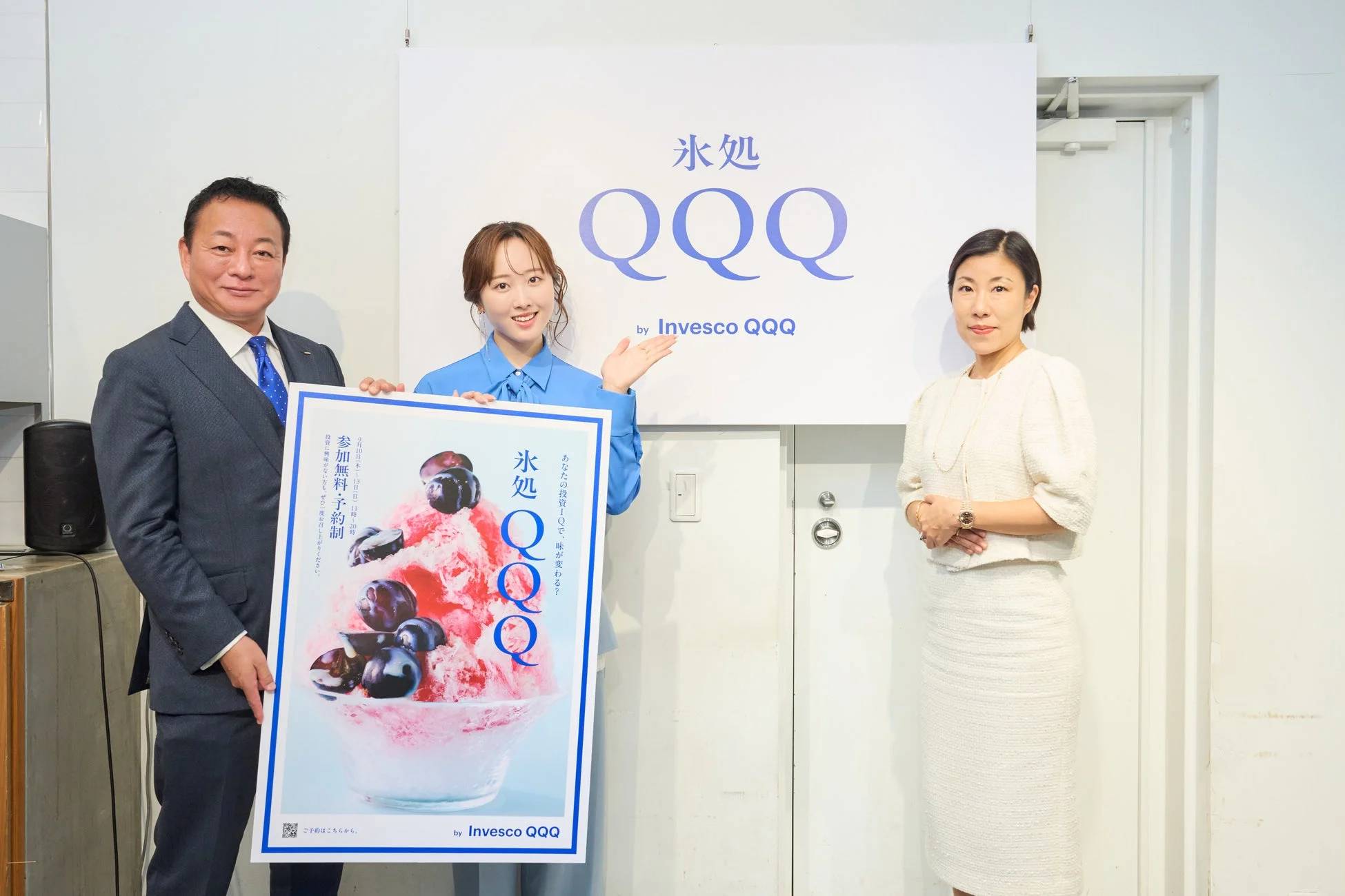氷処 QQQ by Invesco QQQの看板とポスターを持つ3人